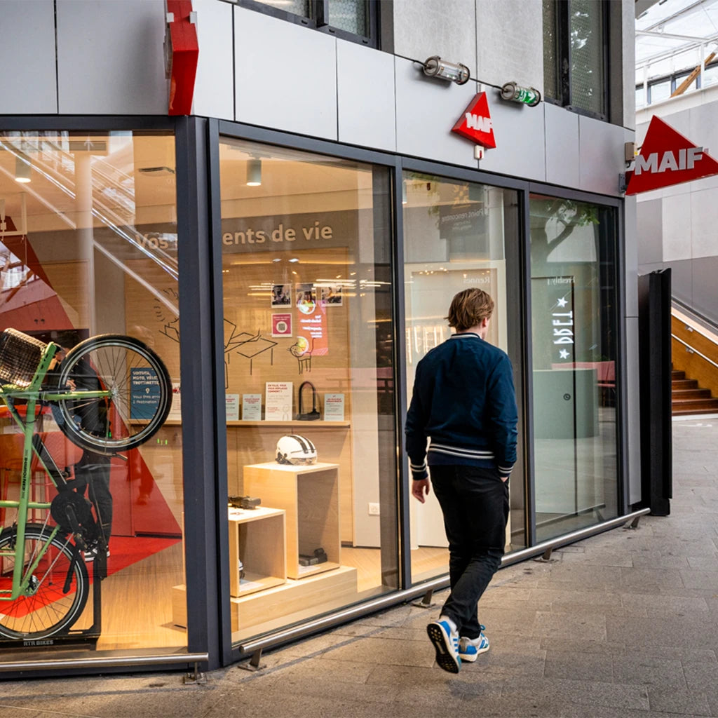 un homme qui marche devant une agence maif assurance